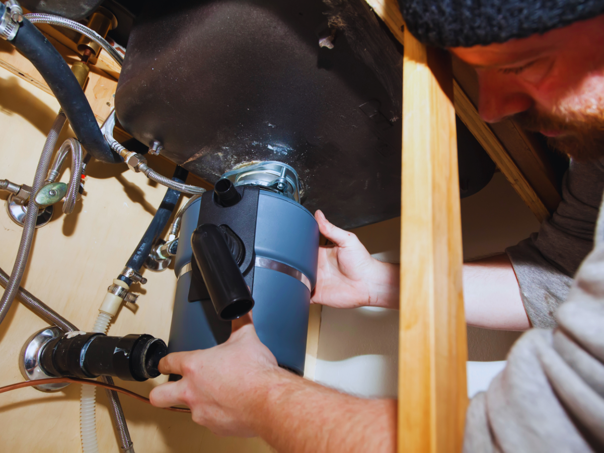 Plumber installing garbage disposal in Gainesville, FL home