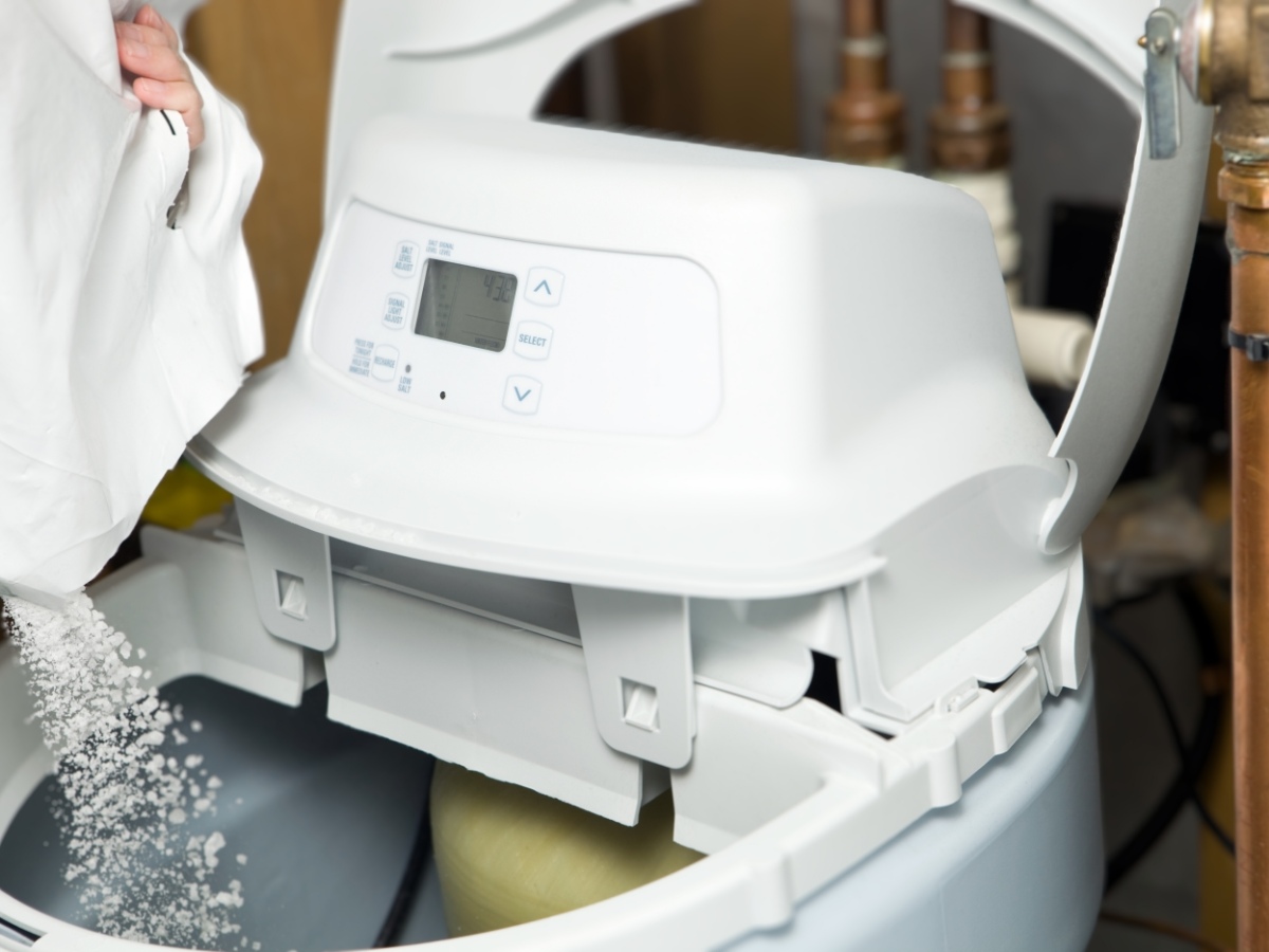 Homeowner adding salt to his water softener 